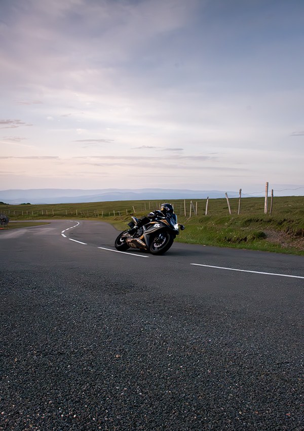 Route de montagne au crépuscule avec moto au loin