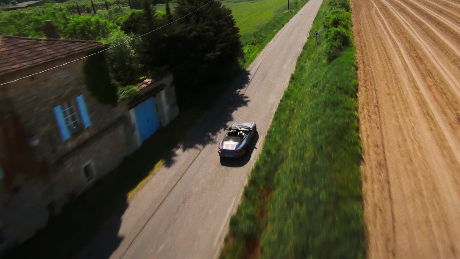 Vue drone FPV au ras du sol, suivi d'un véhicule